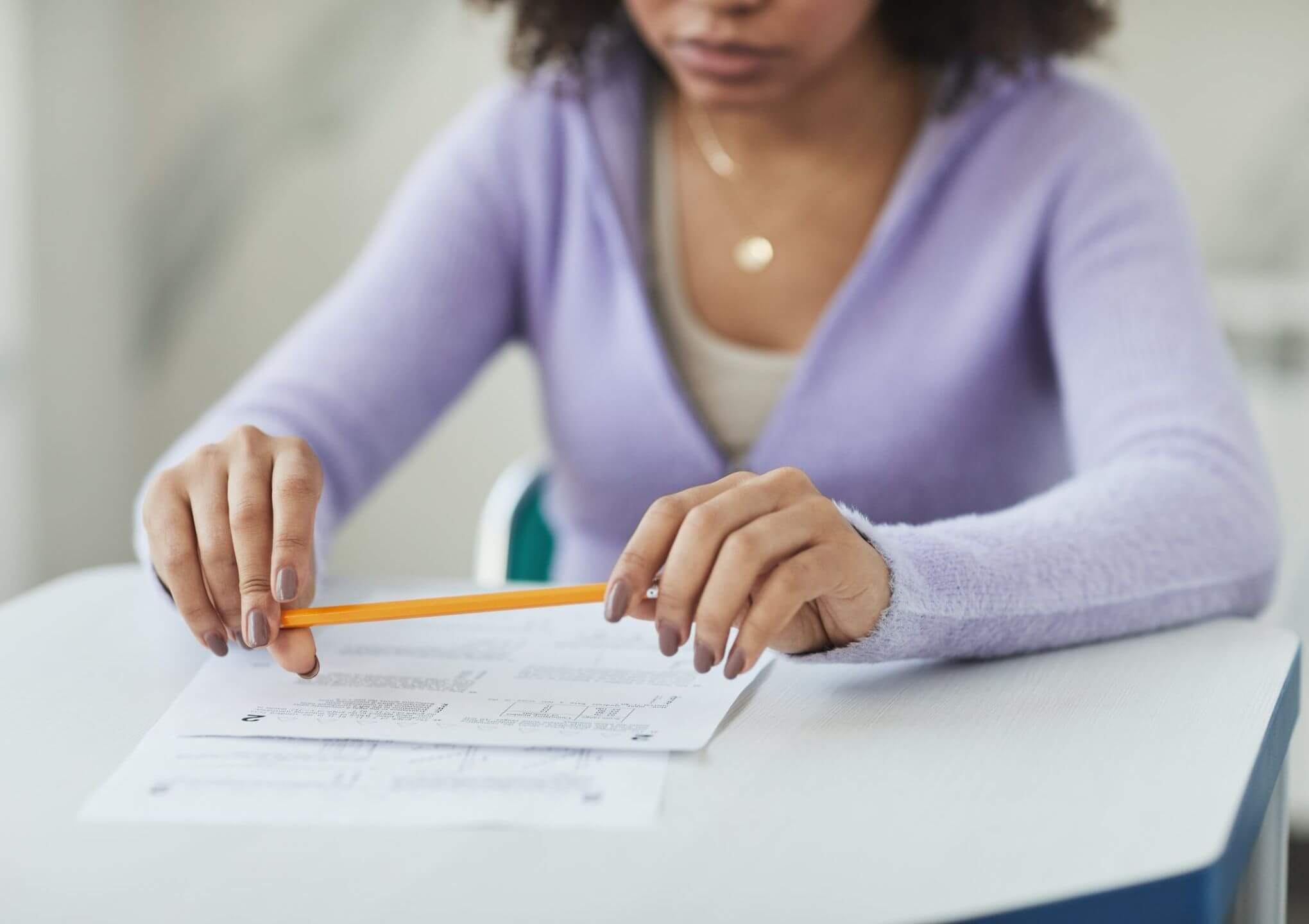 young woman holding a pencil with exam notes